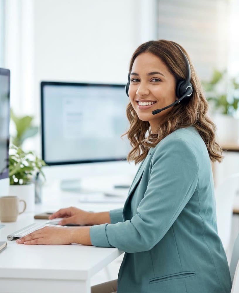 Atendente com headset sorrindo em uma central de atendimento
